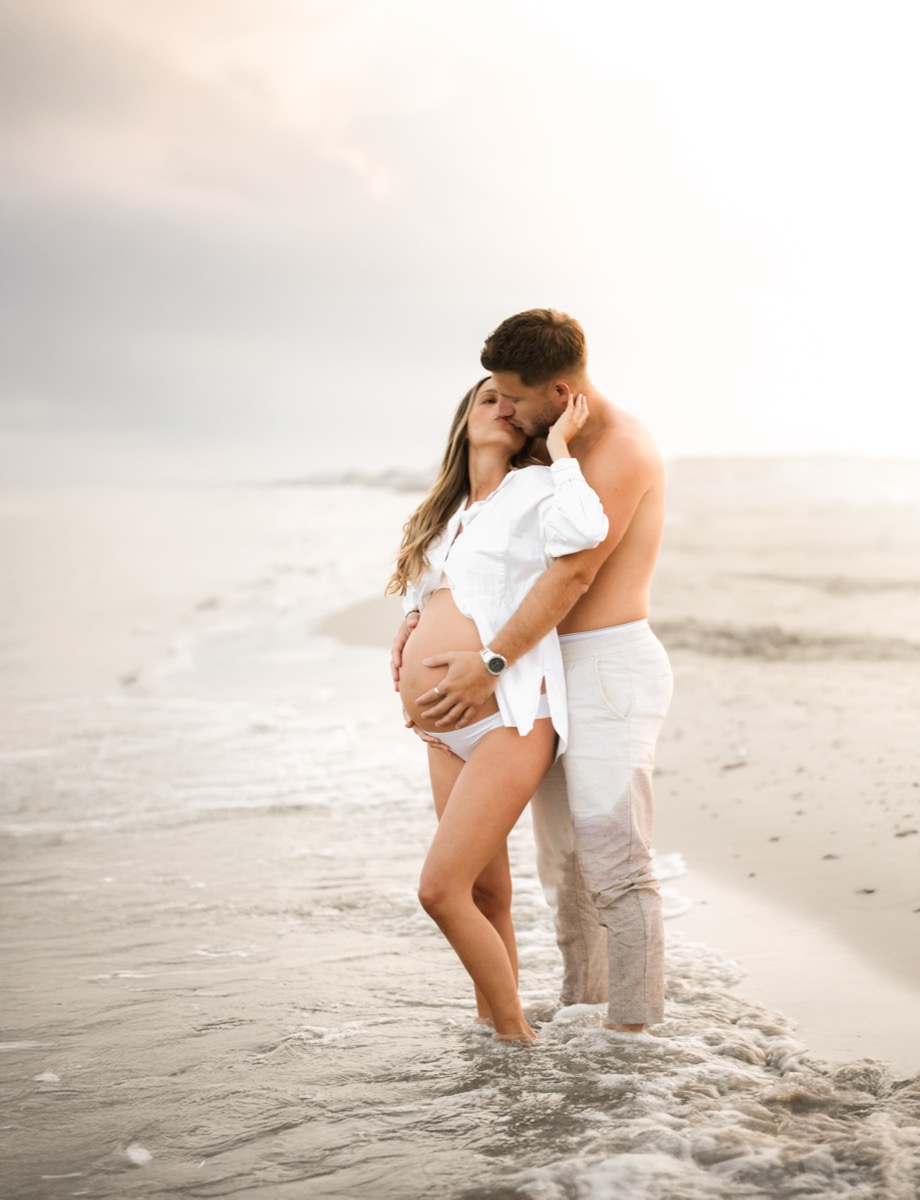 Couple sur la plage, dernières semaines de grossesse