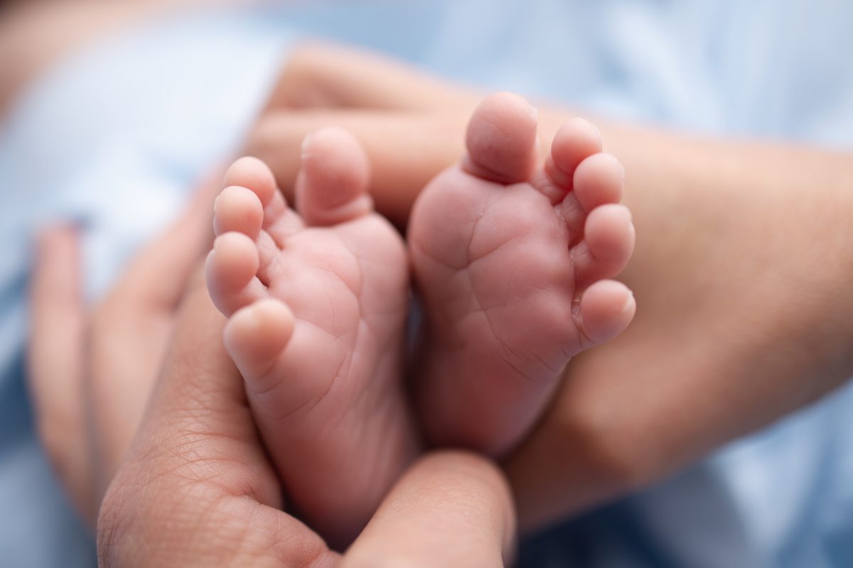 Pieds de nouveau-né dans les mains des parents